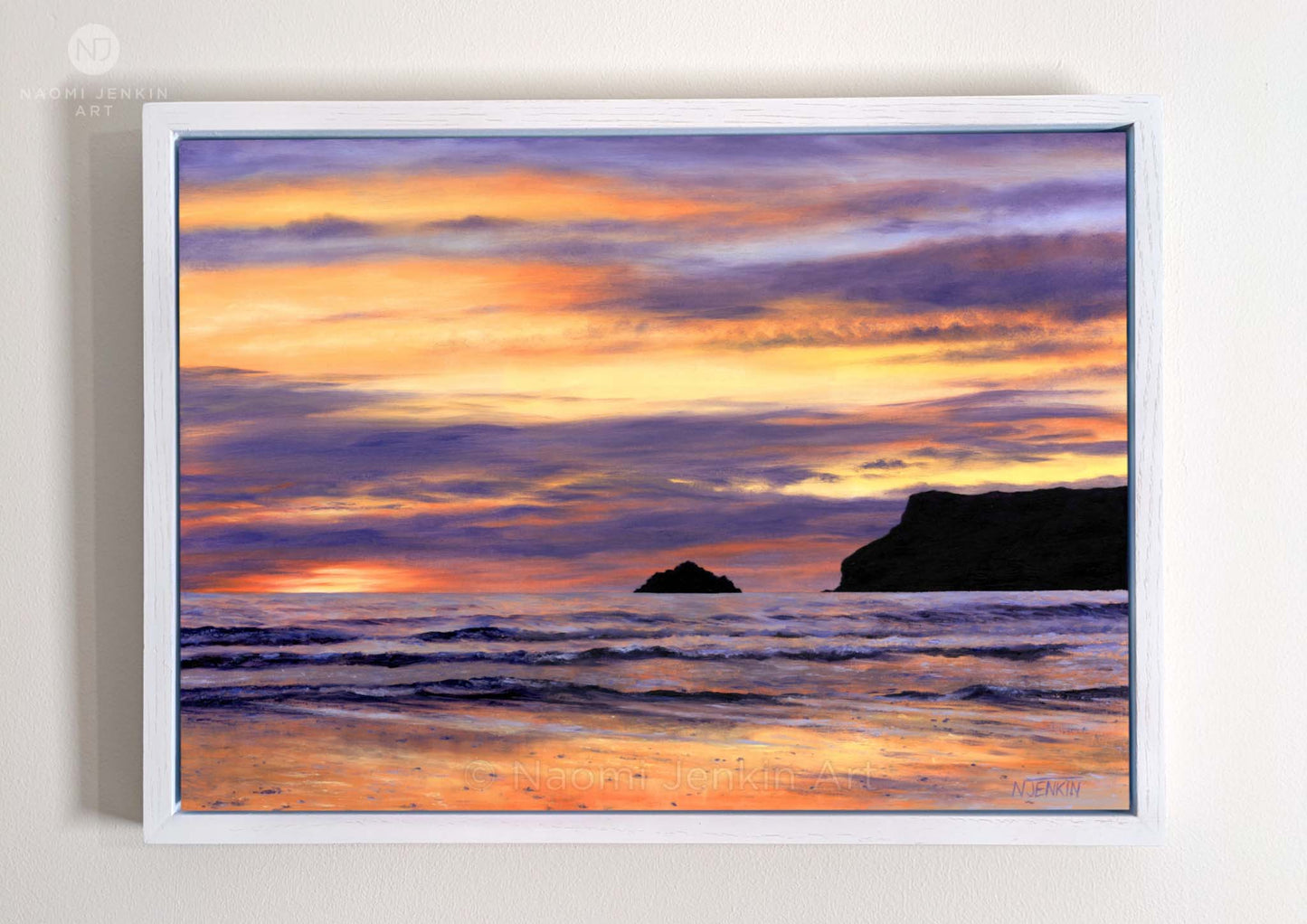 Framed original oil painting by Naomi Jenkin of a sunset at Polzeath Beach, Cornwall, with a vibrant sky of oranges, yellows and reds, purple clouds, and the inky silhouettes of Pentire Point and Newlands Rock