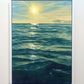 "Last Days Of Summer" - framed original oil painting of an ocean sunset by artist Naomi Jenkin, featuring deep blue-green waves reflecting a bright yellow sun and golden sky. Framed in a white frame. 