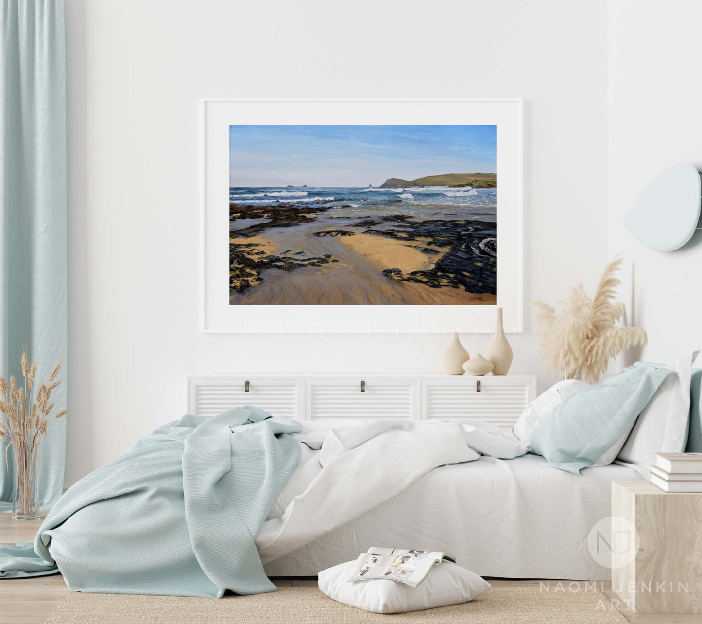Beach print of Constantine Bay by Naomi Jenkin in a white frame and bedroom setting.