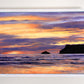 Framed original oil painting by Naomi Jenkin of a sunset at Polzeath Beach, Cornwall, with a vibrant sky of oranges, yellows and reds, purple clouds, and the inky silhouettes of Pentire Point and Newlands Rock