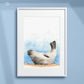 Framed artwork of a seal relaxing on the beach with a blue painted background. Artist - Naomi Jenkin. 