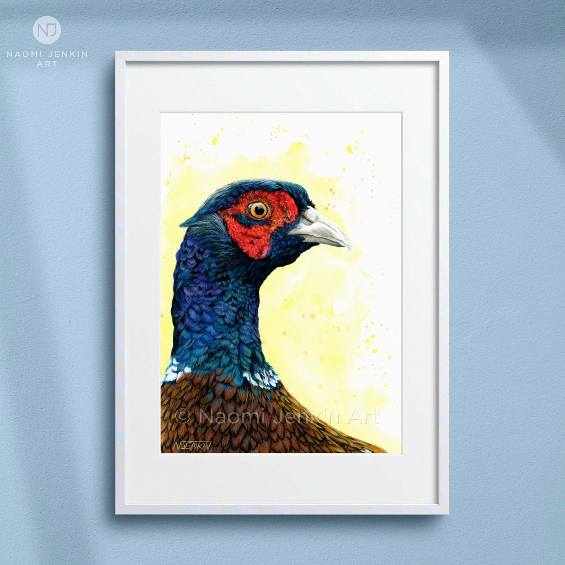 Framed art print of a colourful pheasant drawing with a bright yellow background. Artist - Naomi Jenkin.