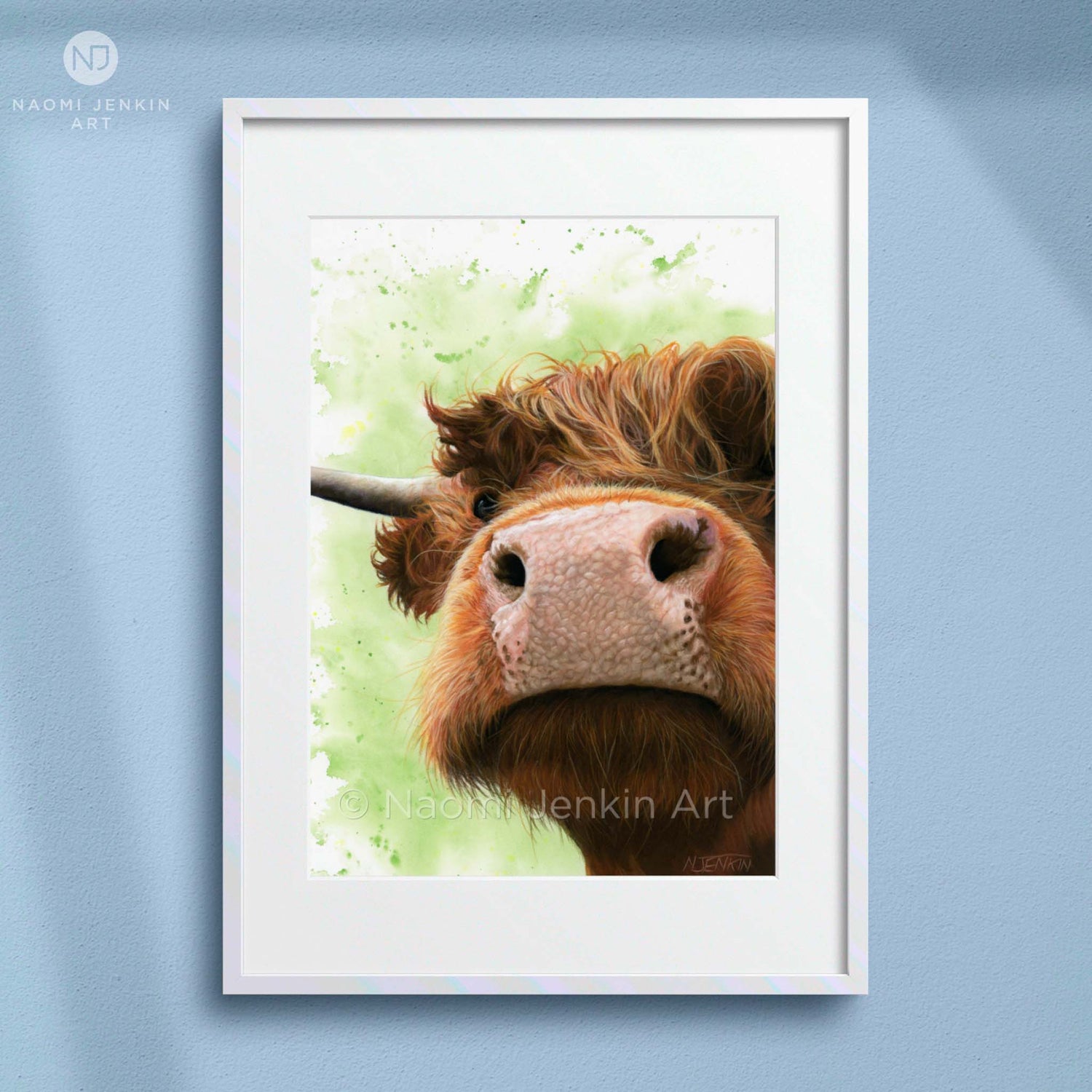Framed artwork of a highland cow with a light green background by Naomi Jenkin Art. 
