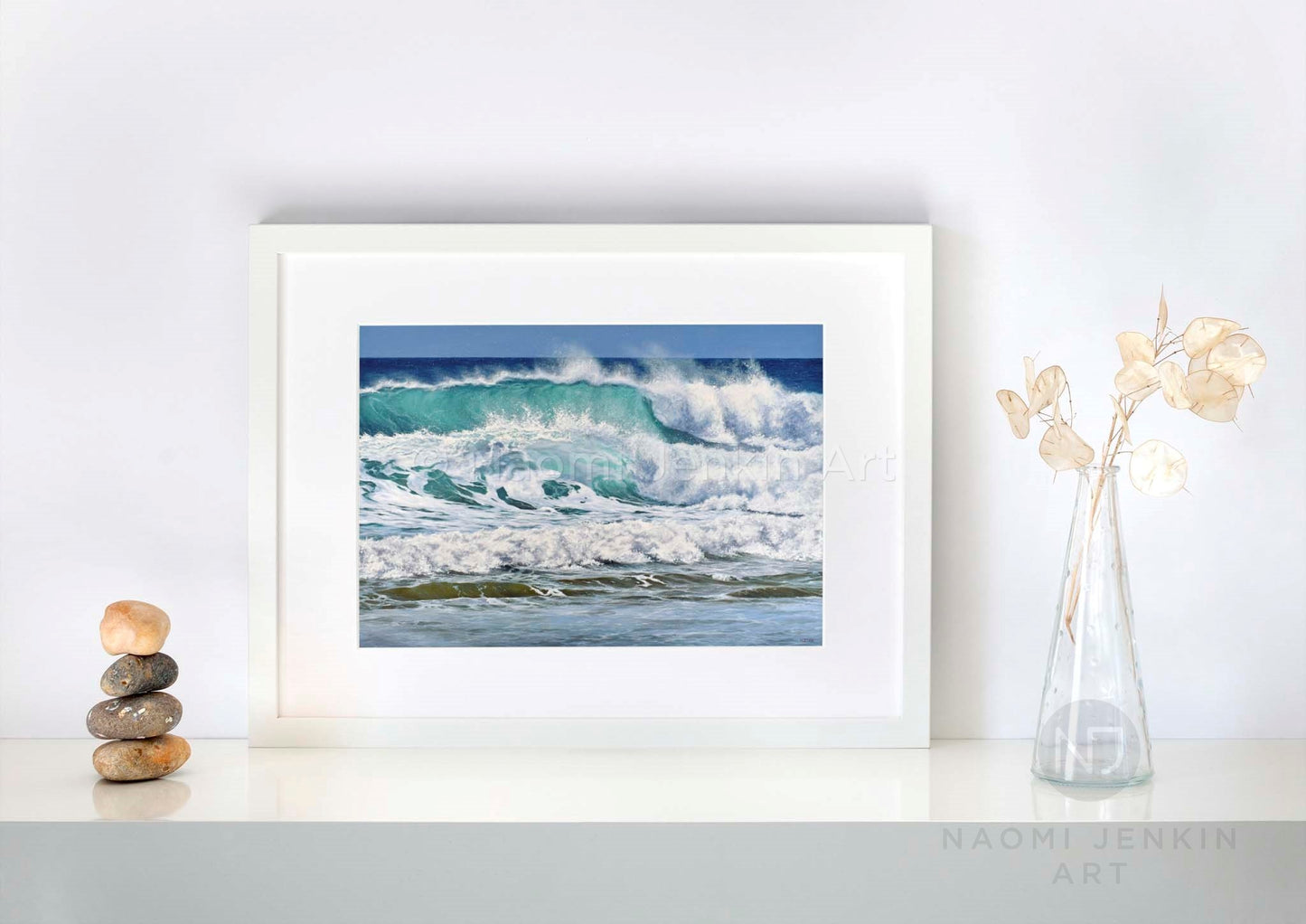 Framed wave art print by seascape artist Naomi Jenkin on a shelf setting